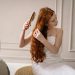 A woman after taking a shower uses one of the Top Detangling Brushes.