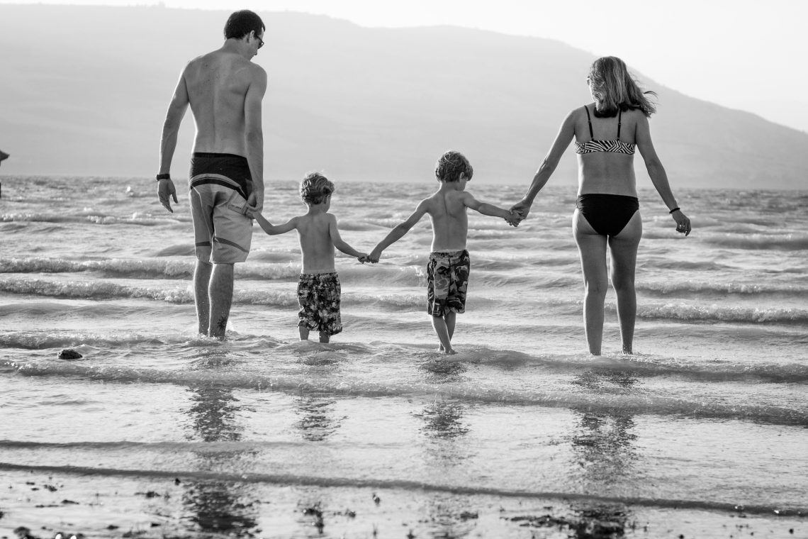 A perfect holiday family photo of a family in the beach.