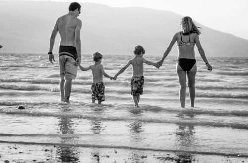 A perfect holiday family photo of a family in the beach.